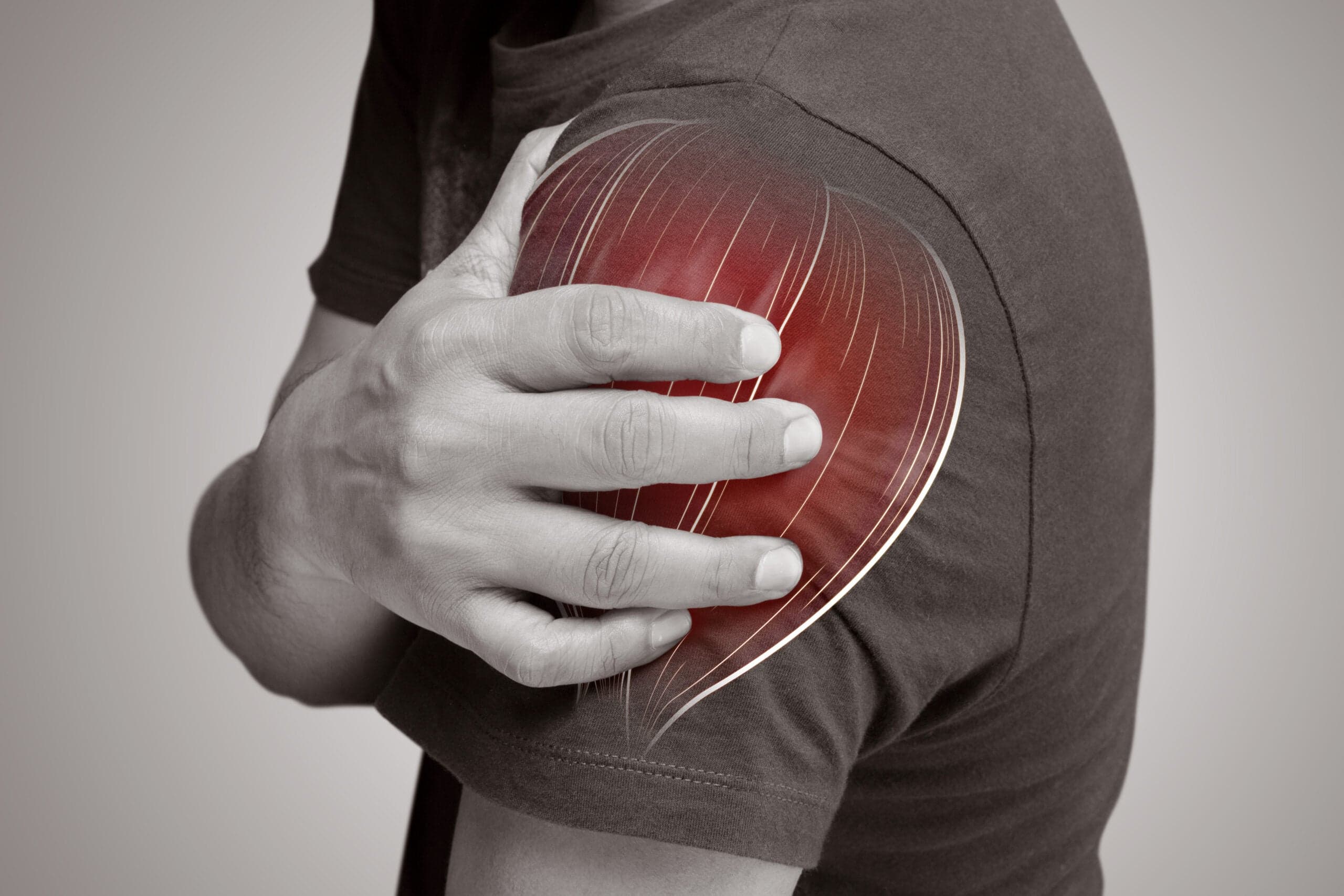Active adult holding a sore arm and shoulder, the upstream links that drive chronic elbow pain, at Thera Performance Lab in Lake Orion, MI