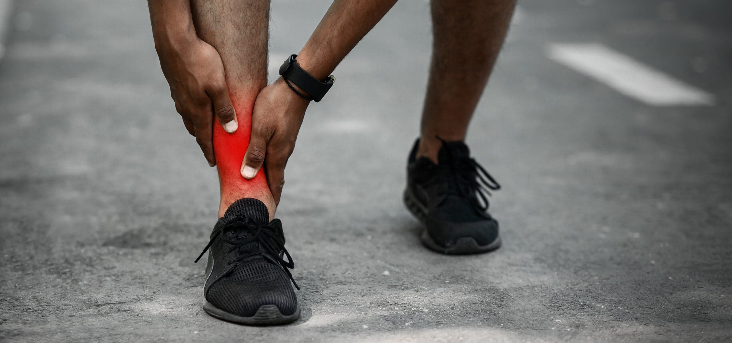 Man with ankle pain while running outdoors